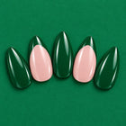Green Flag press-on nails fanned out on green: emerald, and blush with pointed emerald tips.