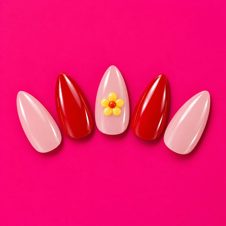 Shaadi Shift press-on nails fanned out on pink: pink and red, with a little yellow flower.