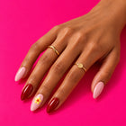 A hand on pink wearing Shaadi Shift: pink and red, with a little yellow flower.