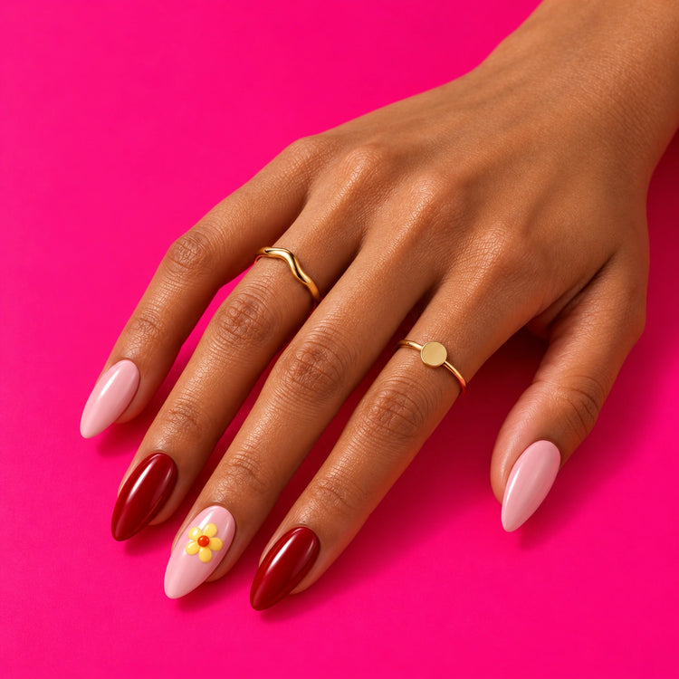 A hand on pink wearing Shaadi Shift: pink and red, with a little yellow flower.