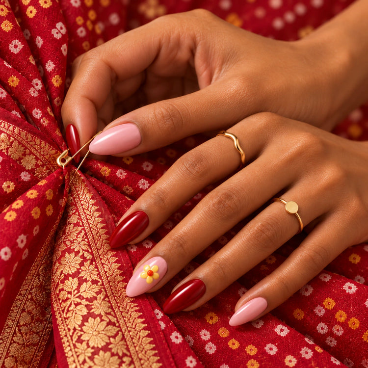 A hand in Shaadi Shift nails fixing a gold safety pin into a red bandhani dupatta.